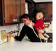 Photo of woman in kitchen using telephone, 1980s.